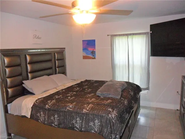 Bedroom featuring a ceiling fan and tile patterned floors