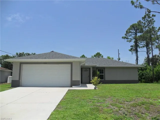 Ranch-style home featuring stucco siding, a front yard, a garage, concrete driveway, and roof with shingles