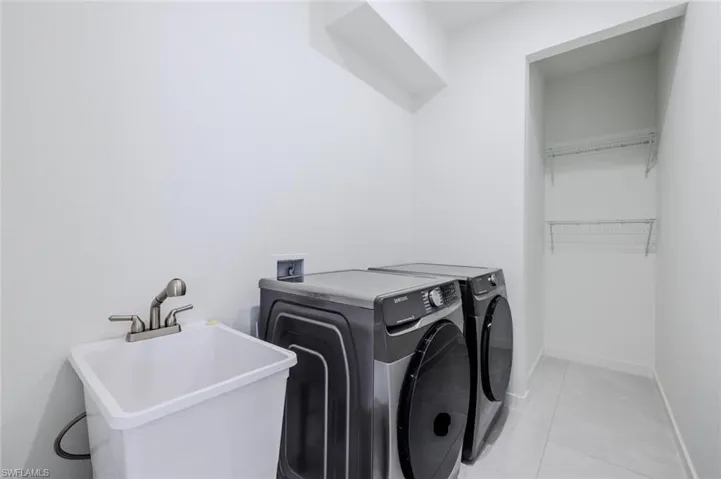 Laundry area featuring tile patterned flooring and washing machine and dryer