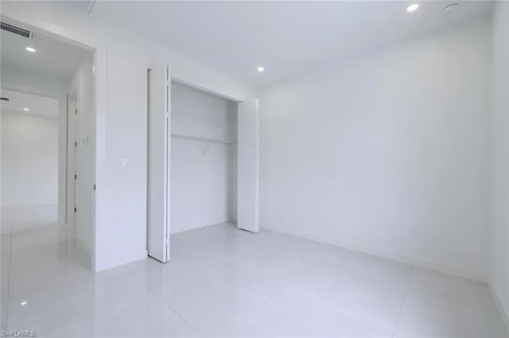 Unfurnished bedroom with recessed lighting, a closet, and light tile patterned floors