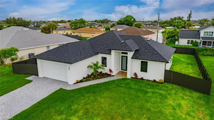 View of front of property with a shingled roof, stucco siding, and a fenced backyard