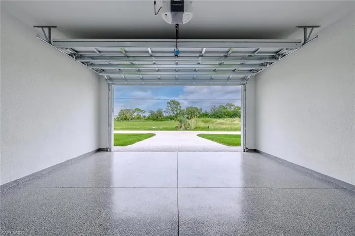 Garage with a textured wall and a garage door opener