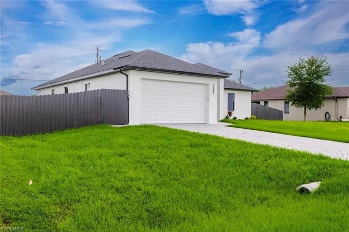 View of property exterior featuring driveway, stucco siding, and a garage