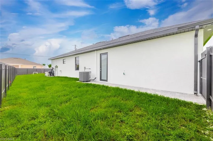 Back of property featuring a fenced backyard, stucco siding, and a patio