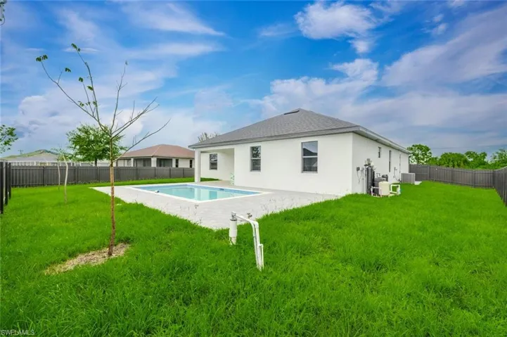 Back of property with a fenced backyard, stucco siding, a patio, and a shingled roof