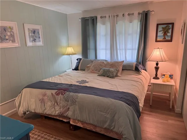 Guest bedroom featuring wood-type laminate flooring, king bed and good sized closet