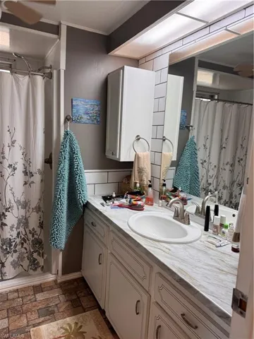Bathroom with a shower with shower curtain and vanity