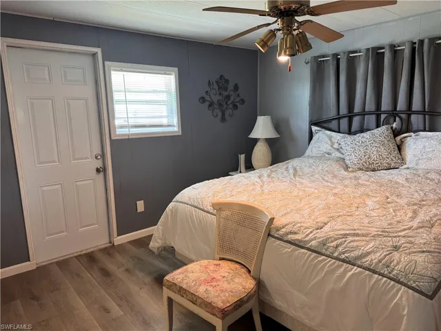 Master bedroom, king bed, panel walls, laminate flooring and access to backyard deck
