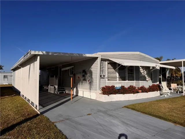 View of front of home with a front lawn and a carport