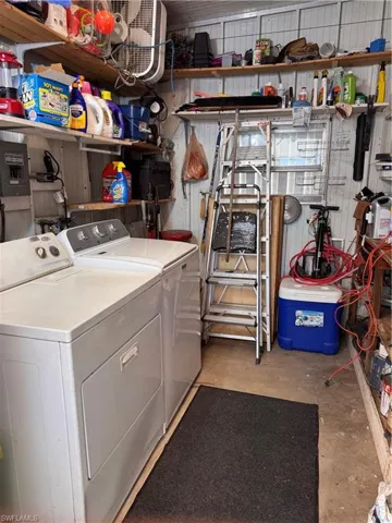 Laundry room in outer shed with washing machine and dryer.  All tools go with the home