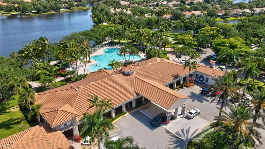 Expansive community center with a tile roof, porte-cochère entrance, and ample parking