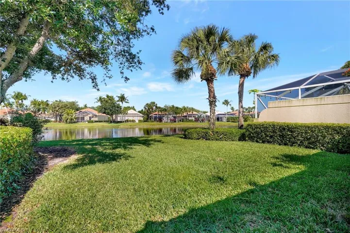 Expansive grassy lawn with established landscaping, including two mature palm trees