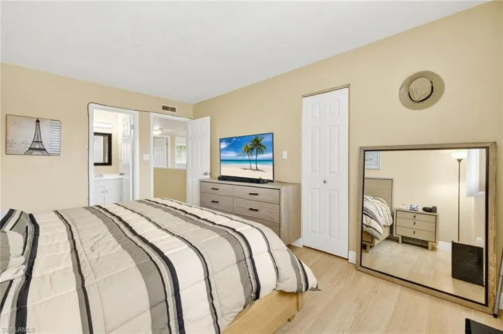 Bedroom with light wood-type flooring and ensuite bath