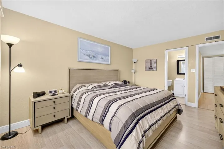 Bedroom with light wood-type flooring and ensuite bathroom