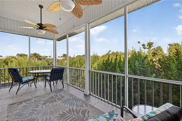 Sunroom / solarium with a ceiling fan and a balcony