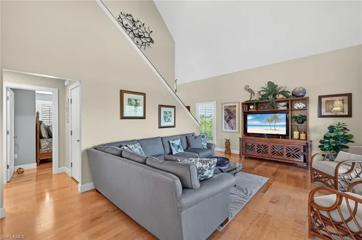 Living area with a high ceiling and light wood finished floors