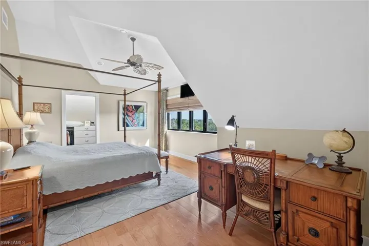 Bedroom with lofted ceiling, light wood-type flooring, and ceiling fan