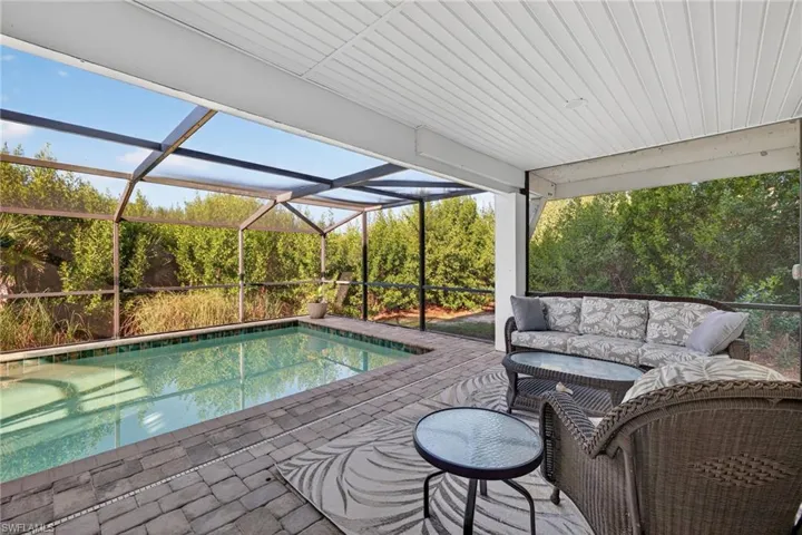 Outdoor pool featuring a lanai and a sunroom