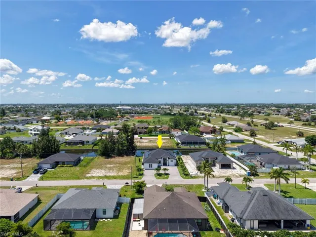 Aerial perspective showcasing the property with a white exterior and dark roof