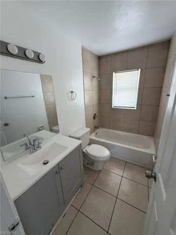 Full bath with bathing tub / shower combination, vanity, and light tile patterned flooring
