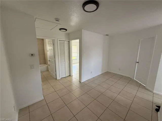 Empty room featuring light tile patterned floors and a textured ceiling