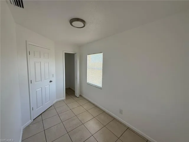 Unfurnished bedroom with light tile patterned floors and a closet