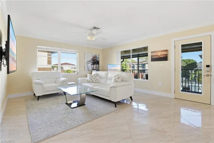 Living area with healthy amount of natural light, crown molding, and an open concept