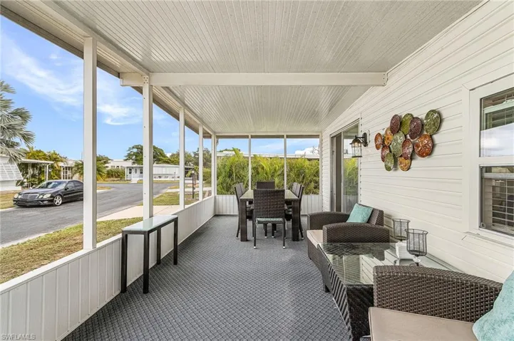 Screened lanai featuring white vinyl siding, a textured grey flooring, and a white paneled ceiling