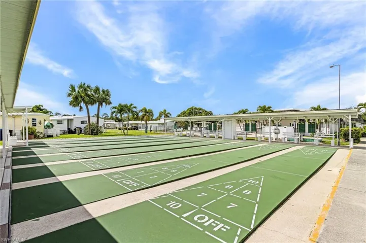 Expansive shuffleboard courts featuring multiple playing lanes and a covered spectator area