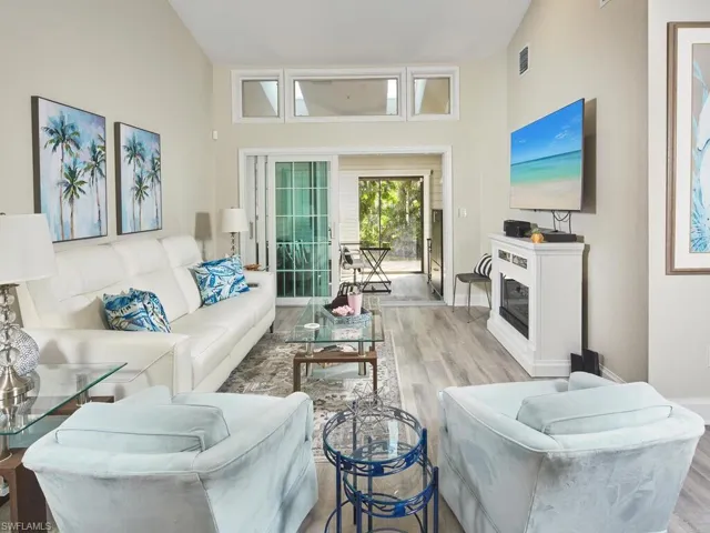 Living room with lofted ceiling, LED lighting & build in shelving front of locked safe closet