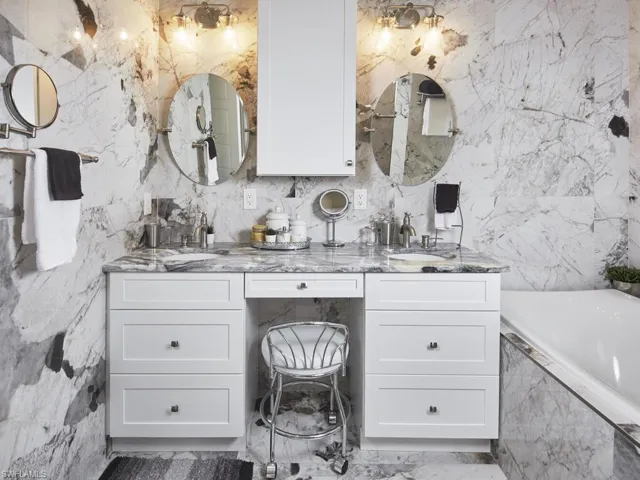 Bathroom featuring vanity and tiled bath