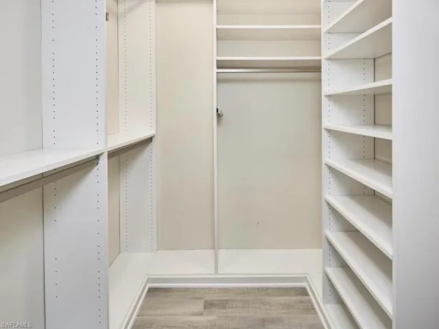 Walk in closet featuring Built-in shelving & wood vinyl flooring