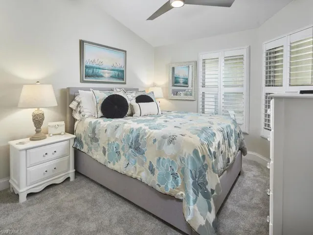 Bedroom with lofted ceiling, grey light colored carpet, and ceiling fan