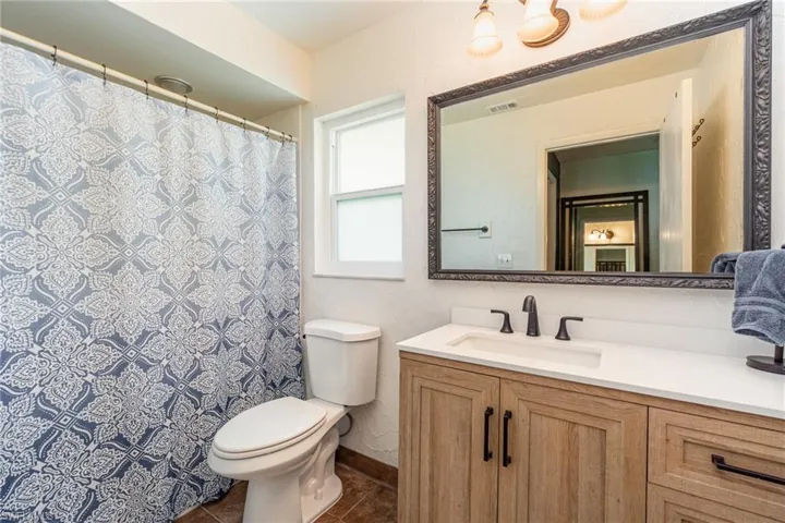 Full bath featuring visible vents, toilet, vanity, and tile patterned flooring