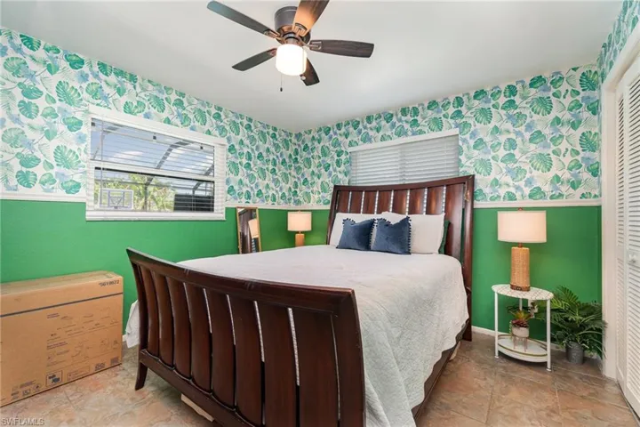 Bedroom 4 featuring a ceiling fan, wainscoting, and wallpapered walls