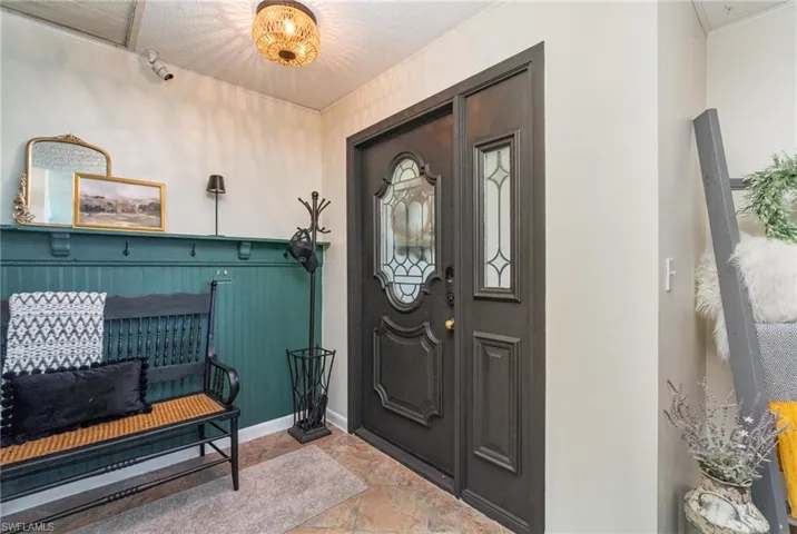 Foyer entrance with stone finish floor and baseboards