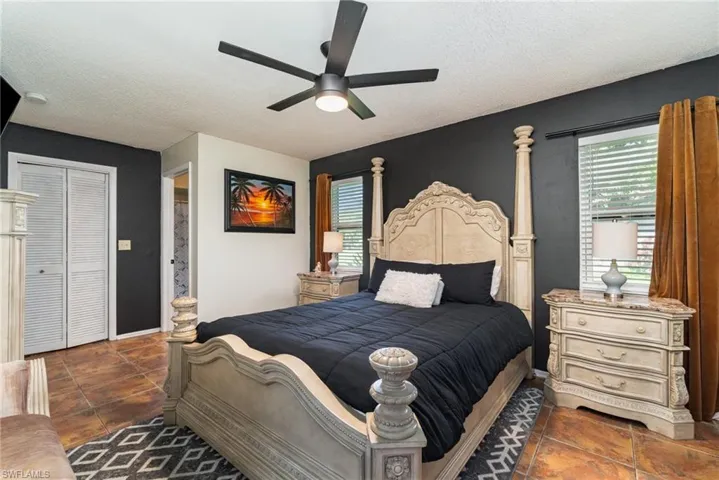 Bedroom with a closet, multiple windows and a ceiling fan