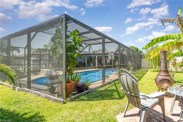 Pool featuring glass enclosure, a yard, and a patio area
