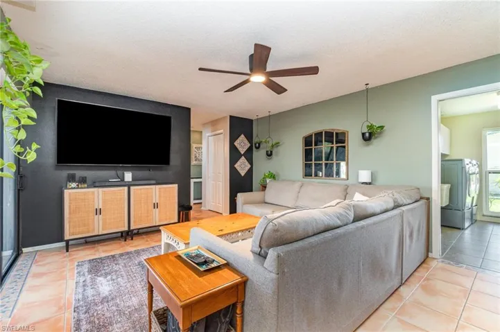 Living room with Great view of the pool, light tile patterned flooring and ceiling fan