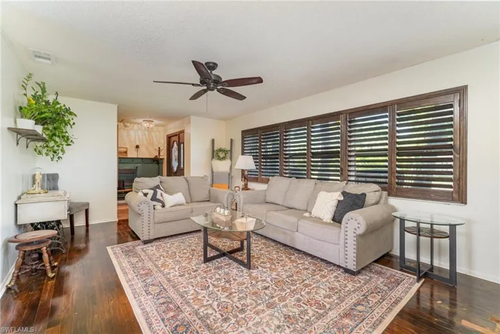 Living area featuring  wood finished floors, visible vents, and ceiling fan