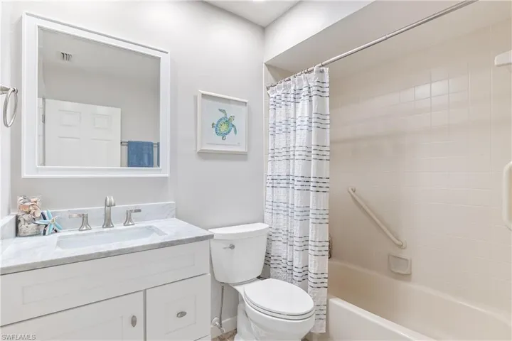 Full bathroom with shower / tub combo with curtain, vanity, and toilet