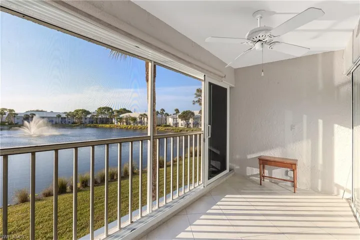 Lanai area with impact resistant slider doors, ceiling fan, and west facing water view