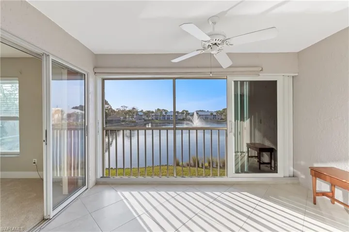 Lanai area with impact resistant slider doors, ceiling fan, and west facing water view