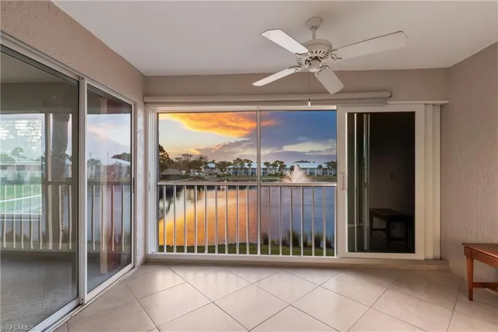 Lanai area with impact resistant slider doors, ceiling fan, and west facing water view