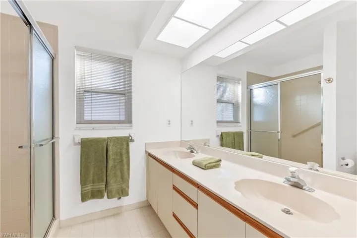 Bathroom featuring duel vanity, tile floors, and walk-in shower