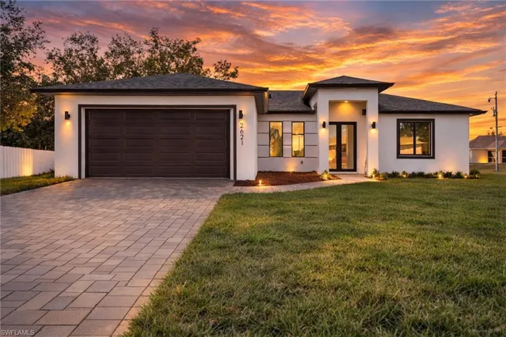 Prairie-style house featuring decorative driveway, stucco siding, and a garage