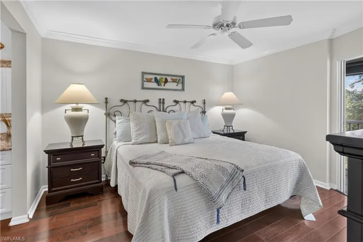 Wood-finish flooring, crown molding, ceiling fan, and a built-in balcony door