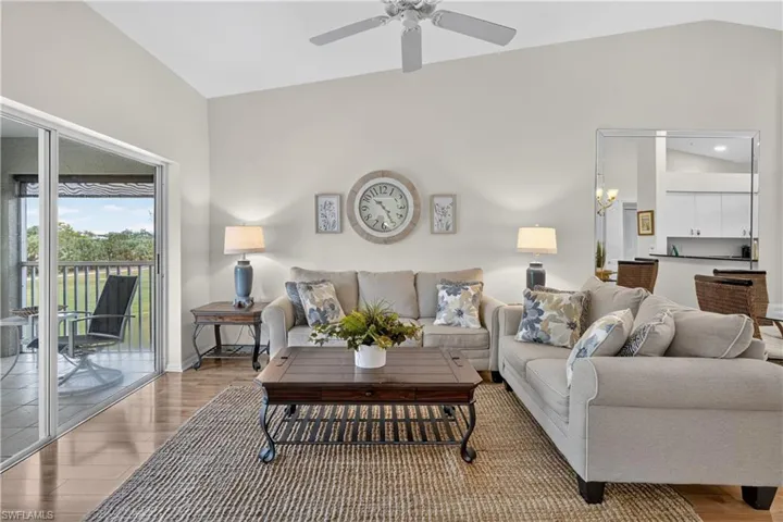 Vaulted ceiling and a ceiling fan, wood-finish flooring, and sliding glass doors to the outdoor patio