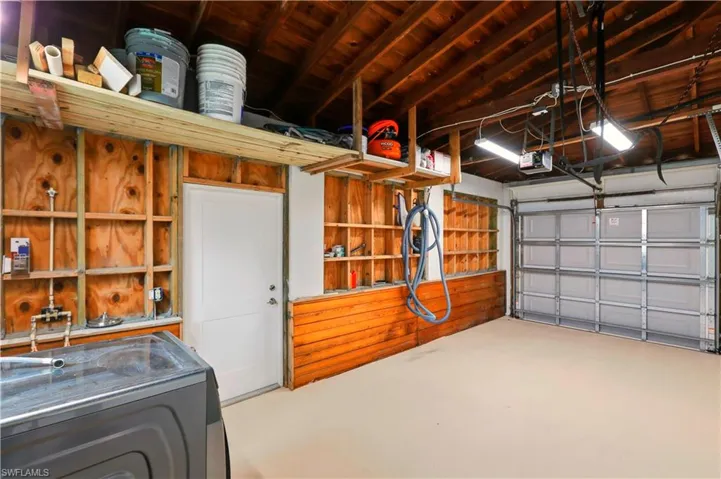 Garage featuring washer / dryer, a garage door opener, and wooden ceiling