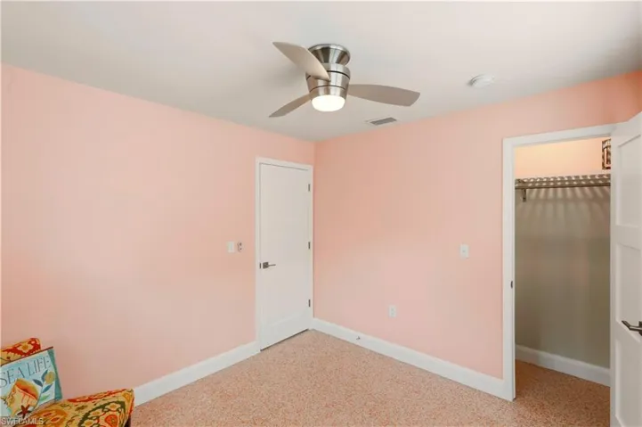 Unfurnished bedroom with a spacious closet and ceiling fan